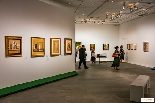 Visiteurs dans une salle de musée admirant des peintures